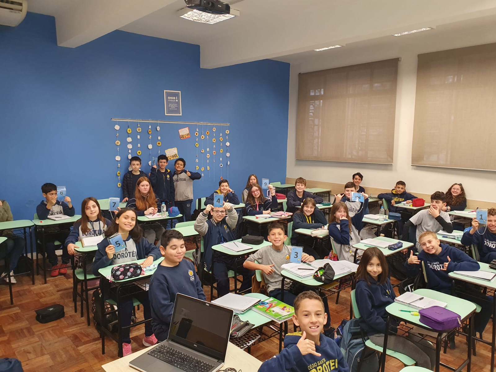 Alunos em sala de aula, sentados em suas classes.